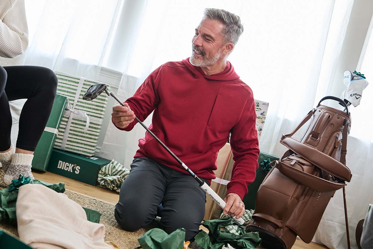 Family in living room while father opens gift