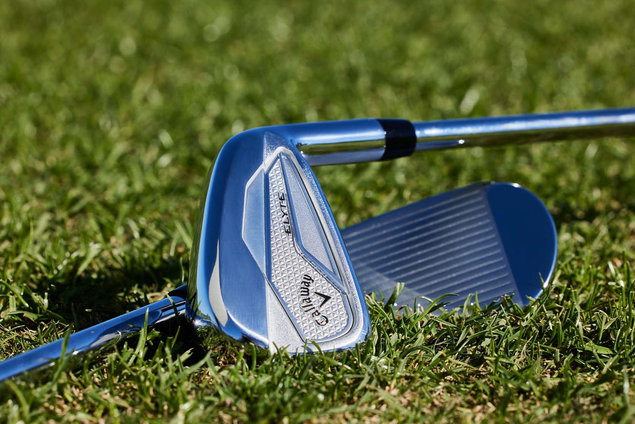 golf iron laying on grass