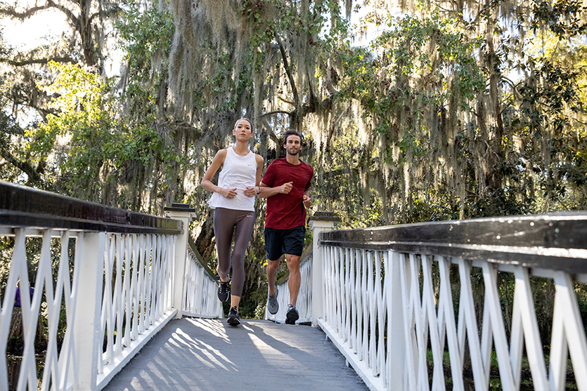 Runners jogging across bridge in daylight