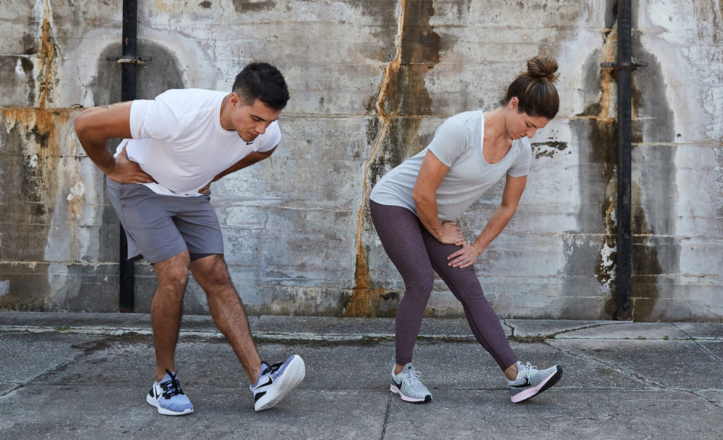 Man and Women doing a standing hamstring stretch