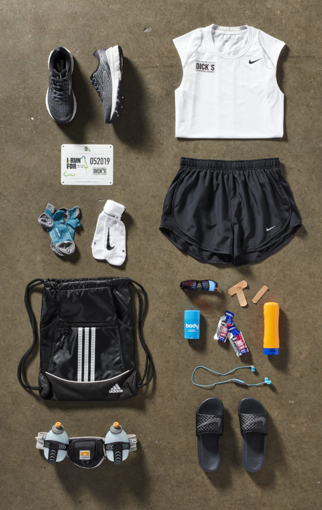 Picture of running gear, shoes, sleveless shirt, running shorts, socks, sunglasses, bandaids, water bottles, etc.