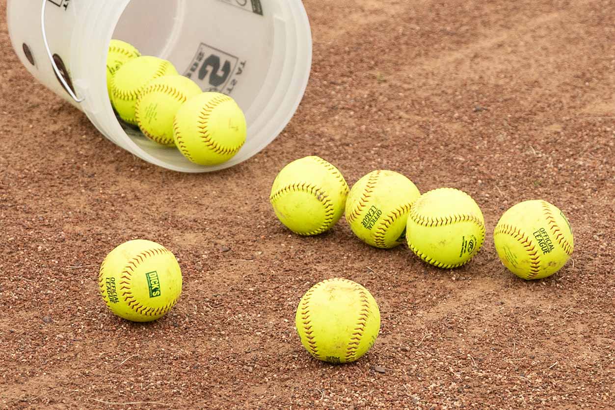 softballs spilling from bucket