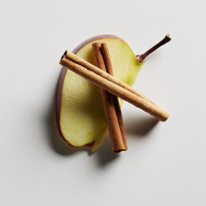 An apple slice and cinnamon sticks