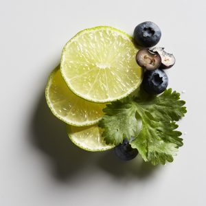 A lime, blueberries, and cilantro