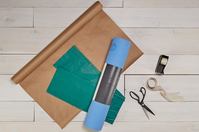 Rolled up yoga mat laying on tissue wrapping paper